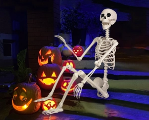 Detailed view of posable 165cm life-size Halloween skeleton sitting in a night garden