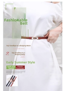 Detail view of slender women's brown leather belt with elegant gold alloy buckle closure