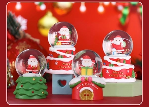 Macro detail of four assorted resin and glass Christmas snow globes with Santa Claus motifs