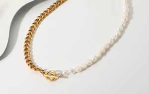 Detail view of gold Cuban chain and freshwater pearl necklace with OT toggle clasp closure