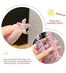Close-up of mini floral hair claws in pink and purple with sparkling center rhinestones