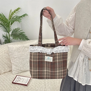 Detailed view of plaid tote bag with white lace trim and colorful HAPPY letter patch