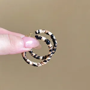 Close-up of vintage leopard print hoop earrings featuring textured fabric and metal base