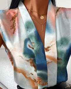Detailed close-up of V-neck printed blouse showing abstract marble pattern and silk texture