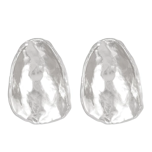 Close-up of silver irregular oval earrings with glossy hammered texture and metallic finish