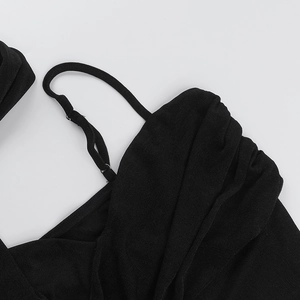 Macro detail of black knitted fabric texture with pleated design and thin shoulder straps