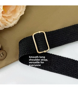 Détail de la bandoulière tressée noire avec boucle de réglage en métal doré