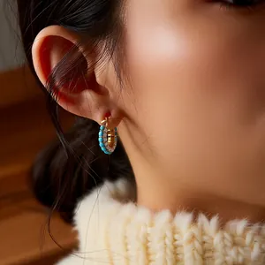 Vintage gold plated hoop earrings with turquoise beads and white zircons on model