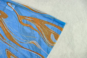 Macro d'un tissu mesh bleu et orange en 100% polyester avec imprimé tie-dye abstrait