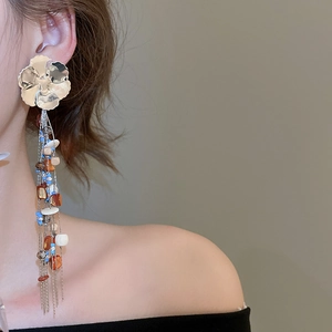 Detail of floral earrings with long tassels and mixed beads in bohemian style
