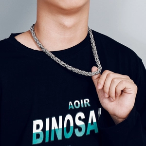 Close-up of a silver stainless steel Byzantine chain necklace worn by a male model