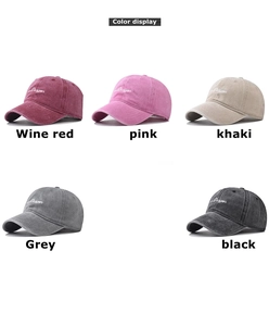 Close-up of five washed cotton baseball caps in wine red, pink, khaki, grey, and black colors