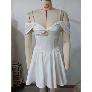 Detail des weißen Minikleides mit eleganten Perle-Trägern und Cut-Out Design vorne