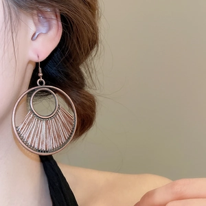 Close-up of vintage bronze bohemian geometric round earrings worn by a model
