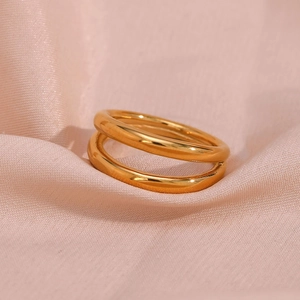 Macro shot of double layered 18K gold plated stainless steel rings on pink silk fabric