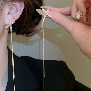 Détail de boucles d'oreilles à franges dorées avec breloques étoiles en cristal sur le mannequin