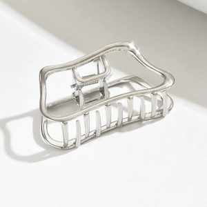 Detailed view of glossy silver cloud-shaped metal hair claw with hollow geometric design