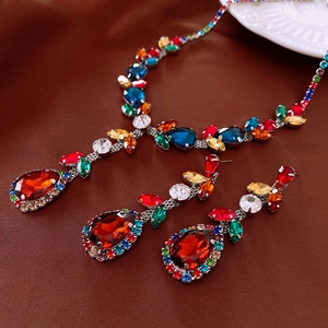 Macro view of vintage silver necklace and earrings with red pear-cut zircon and crystals