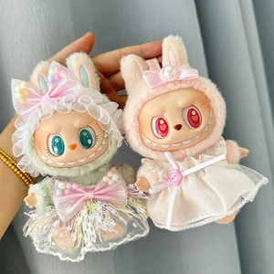Close-up of plush doll outfits in green and pink bunny styles with delicate lace bows