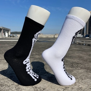 Vue détaillée de chaussettes mi-mollet noires et blanches avec motifs d'os en extérieur