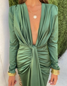 Détail de la robe en satin vert avec décolleté en V plongeant et nœud torsadé élégant