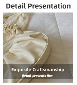 Detail shot of the cream scrunchie handle on the pleated cloud-style handbag texture