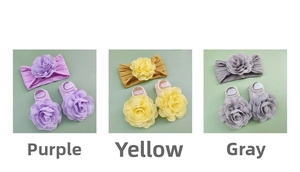 Detail of infant headband and anti-slip sock set with large flowers in purple, yellow and grey