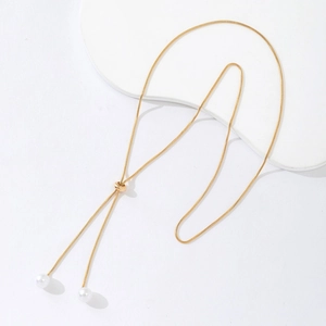 Adjustable gold snake chain necklace with white pearls on a minimalist pedestal