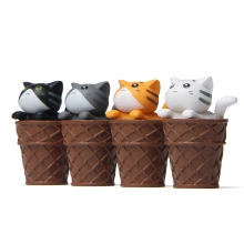 Close-up of four miniature cat figurines inside waffle cones in various fur colors