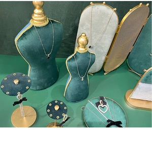 Deep green velvet jewelry display set with mannequin bust and gold metal frame detailing