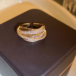 Detail of gold layered zircon ring showing intricate pave-set stones and open design