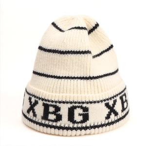 Detail of the knit texture and XBG letter embroidery on the off-white striped beanie