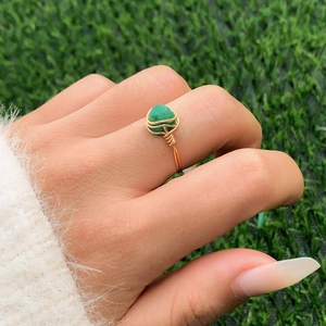 Detail view of handmade gold wire wrapped ring featuring a green irregular raw stone inlay