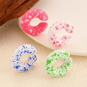 Colorful C-shaped acrylic ear cuffs with gradient splash ink effect on wooden stands