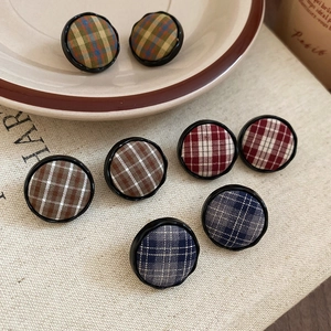 Detail showing vintage plaid fabric round stud earrings in red, blue, and khaki colors