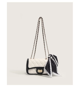 Détail du sac à chaîne matelassé blanc et noir avec foulard en soie et fermoir métal
