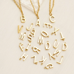 Detailed macro view showing the complete set of A-Z gold initial letter pendants