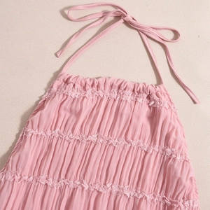 Close-up of pink ruched fabric with intricate lace trim on backless party dress