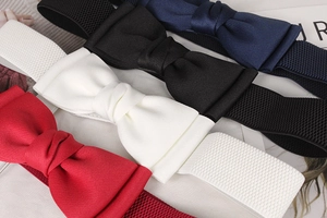 Detail view of elastic waist belts in four colors featuring large fabric bow decorations