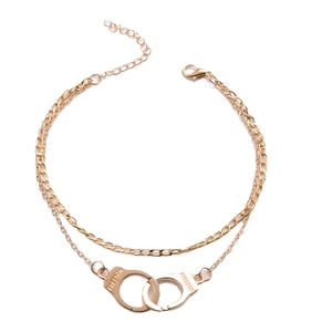 Double-layer gold ankle bracelet featuring freedom handcuff pendants in polished finish