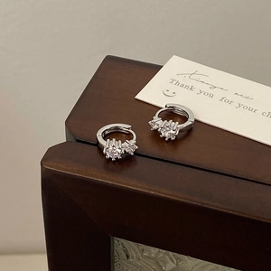 Macro view of silver S925 earrings featuring three sparkling cubic zirconia stones