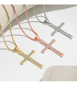Detailed view of three cross necklaces in gold, rose gold, and silver with zircon inlays