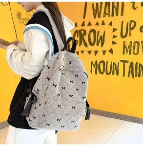 Grey corduroy quilted backpack with black ribbon details and bow patterns for women