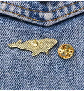 Detail view of the whale badge golden alloy back structure with butterfly clasp closure