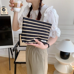 Detail of striped canvas pouch featuring Sozakka label in a cozy home interior setting
