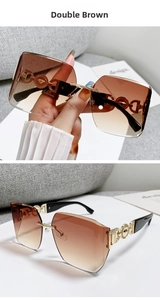 Detail view of gold metal temples with chain design on oversized brown gradient sunglasses