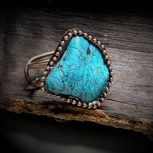 Macro detail of natural turquoise ring set in vintage bronze base with bead decoration