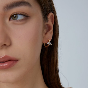 Elegant gold leaf earrings for women with cubic zirconia geometric design on model