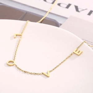 Gros plan des pendentifs lettres LOVE dorées sur une chaîne fine pour femmes