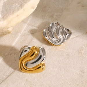 Boucles d'oreilles géométriques bicolores en acier inoxydable sur fond de pierre